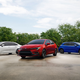 A photo of three new models of Toyota Corolla including two sedans and a hatchback.